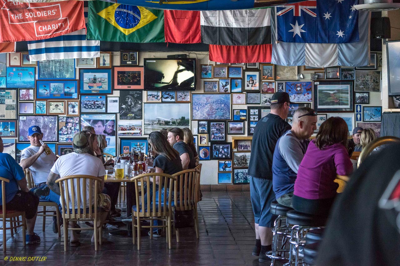 Patrons enjoy beverages inside a photo-covered restaurant at Skydive Perris