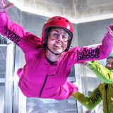 Woman in pink flight suit in the wind tunnel at Skydive Perris