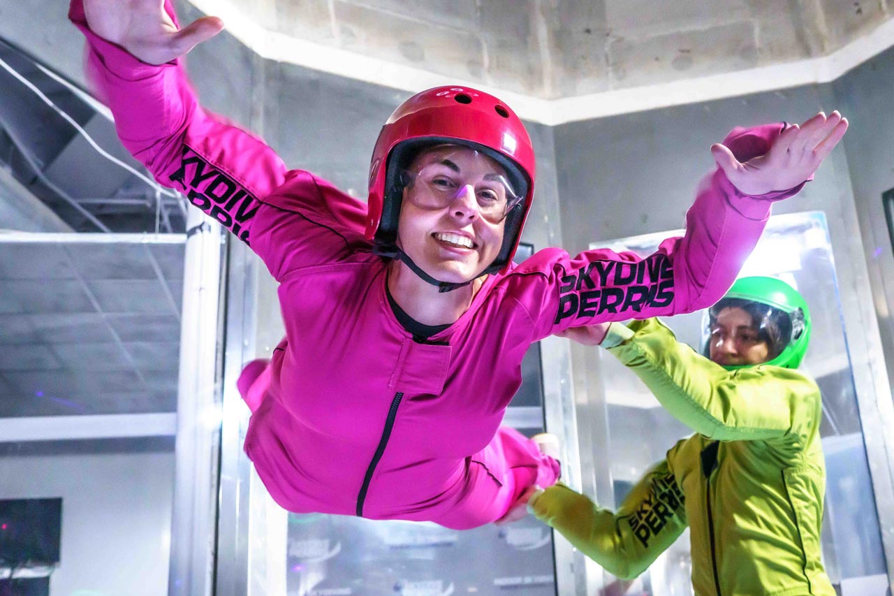 Woman in pink flight suit in the wind tunnel at Skydive Perris