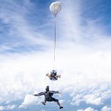 Outside view of a videographer capturing a tandem skydiving student and instructor in freefall