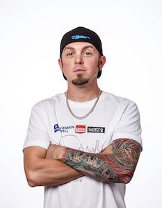 Professional skydiver Curt Bartholomew with a white shirt, black hat, and folded arms