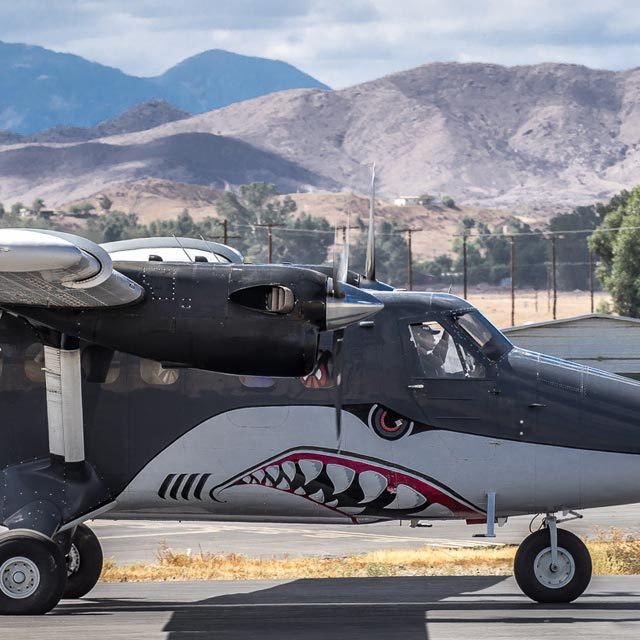 Grey and white twin turbine airplane painted like a shark