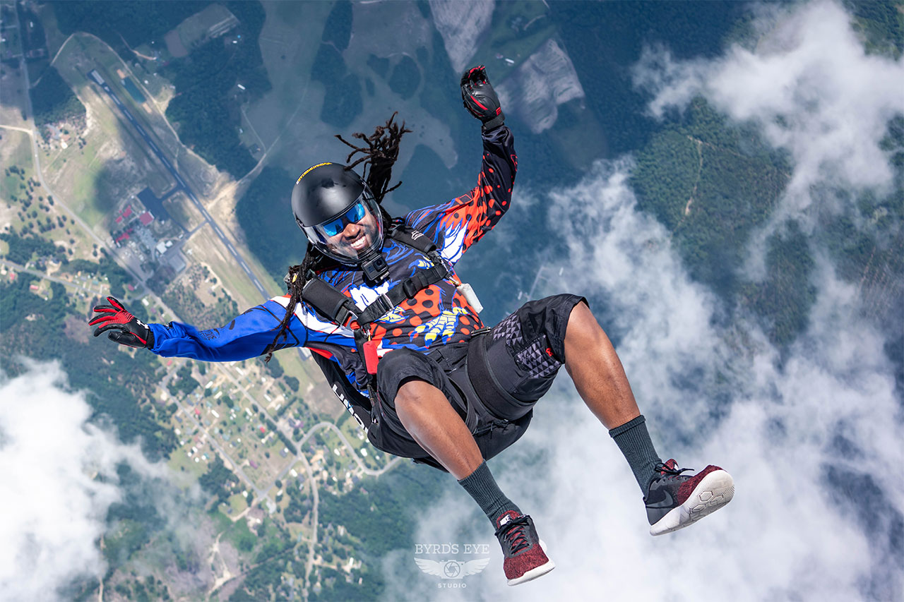 Licensed skydiver in freefall smiling at camera