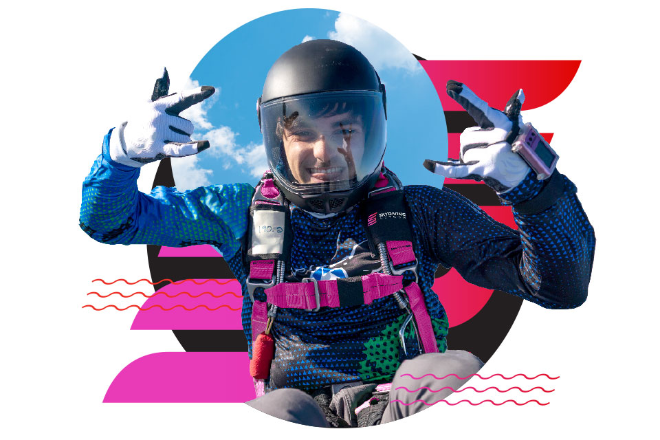 A smiling skydiver in a helmet and gear makes hand gestures, with a bright sky in the background and colorful graphic shapes behind him.