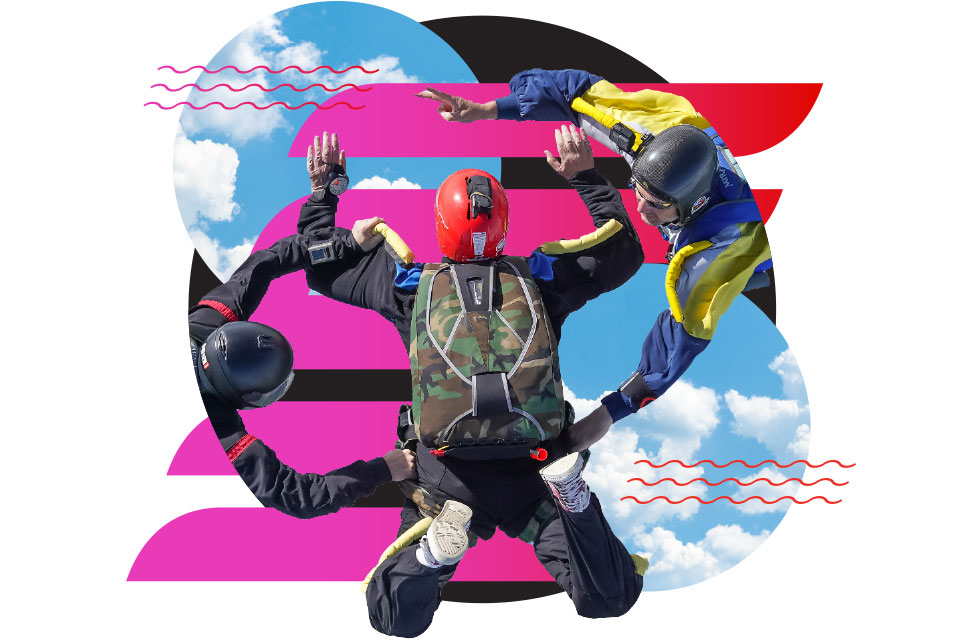 Three skydivers in colorful gear form a circle while free-falling against a blue sky with clouds, overlaid with abstract pink, black, and red graphic shapes.